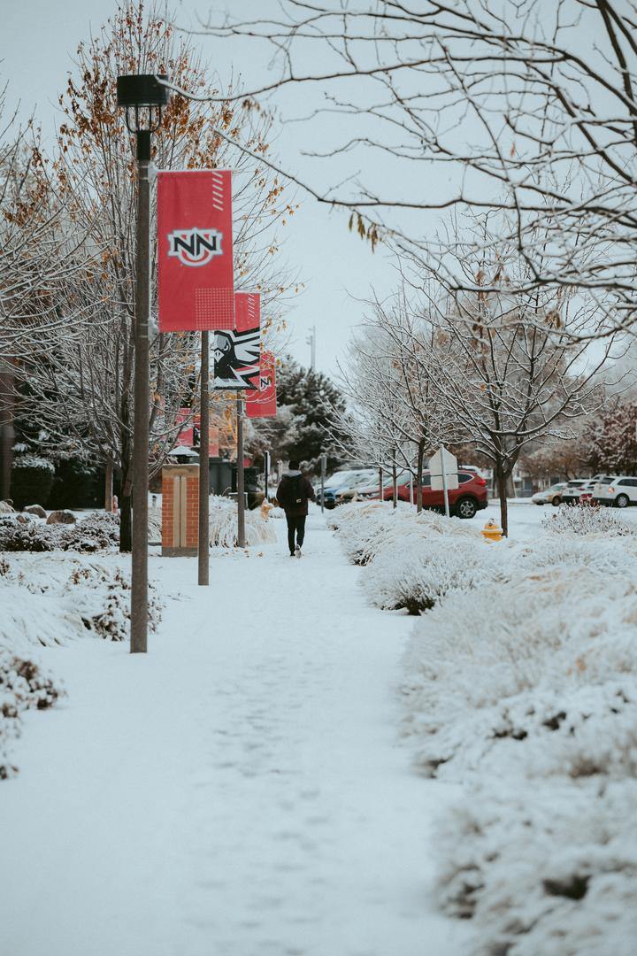 student walking to class on snowy sidewalk