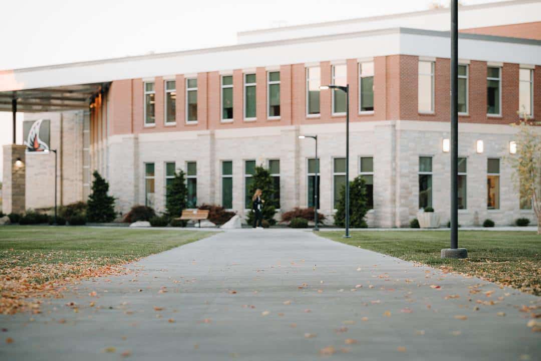 student walking by exterior of building