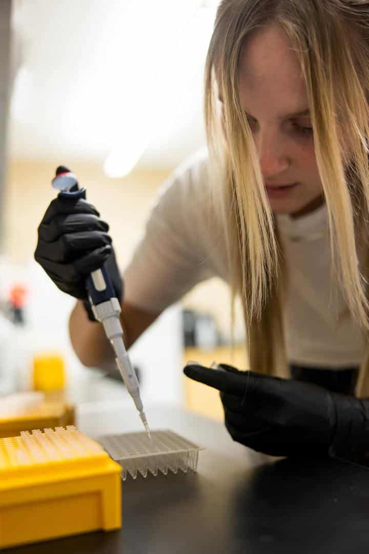 student putting syringe in vials