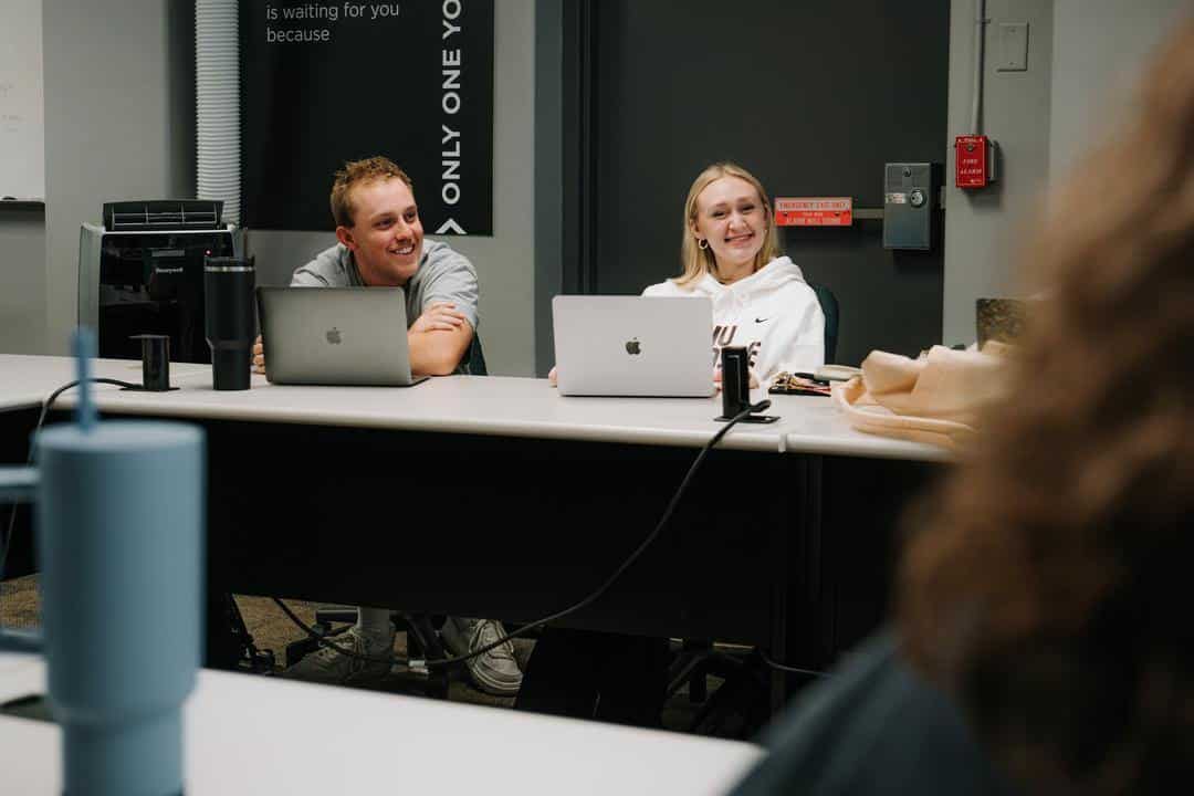 students smiling and taking notes