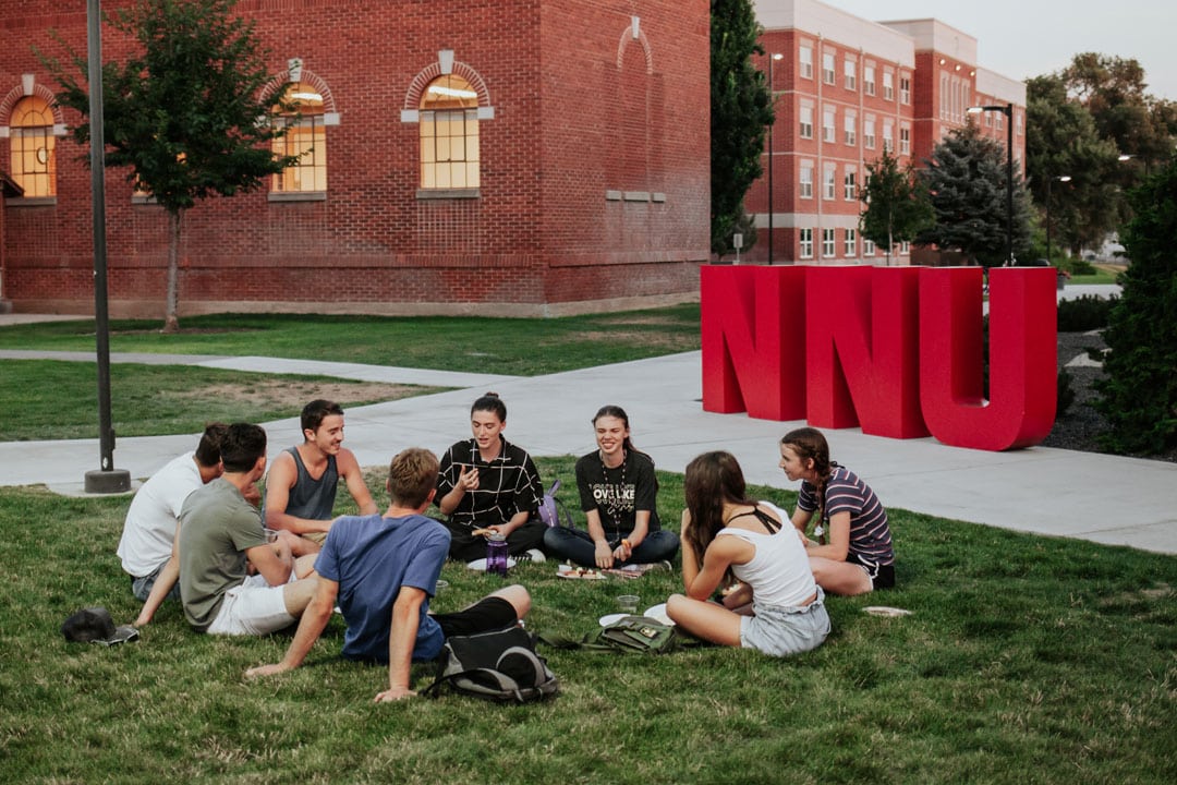 students sitting on grass outside