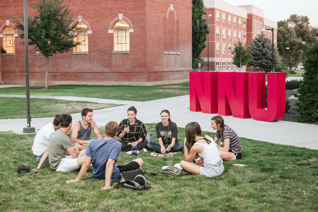 students sitting on grass outside