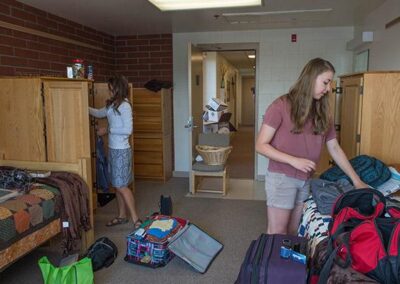 females unpacking dorm room