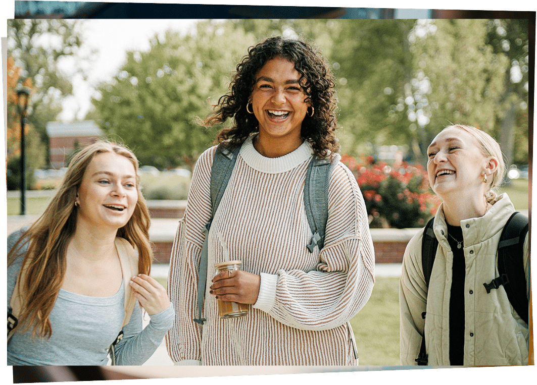 three girls with book bags laughing 