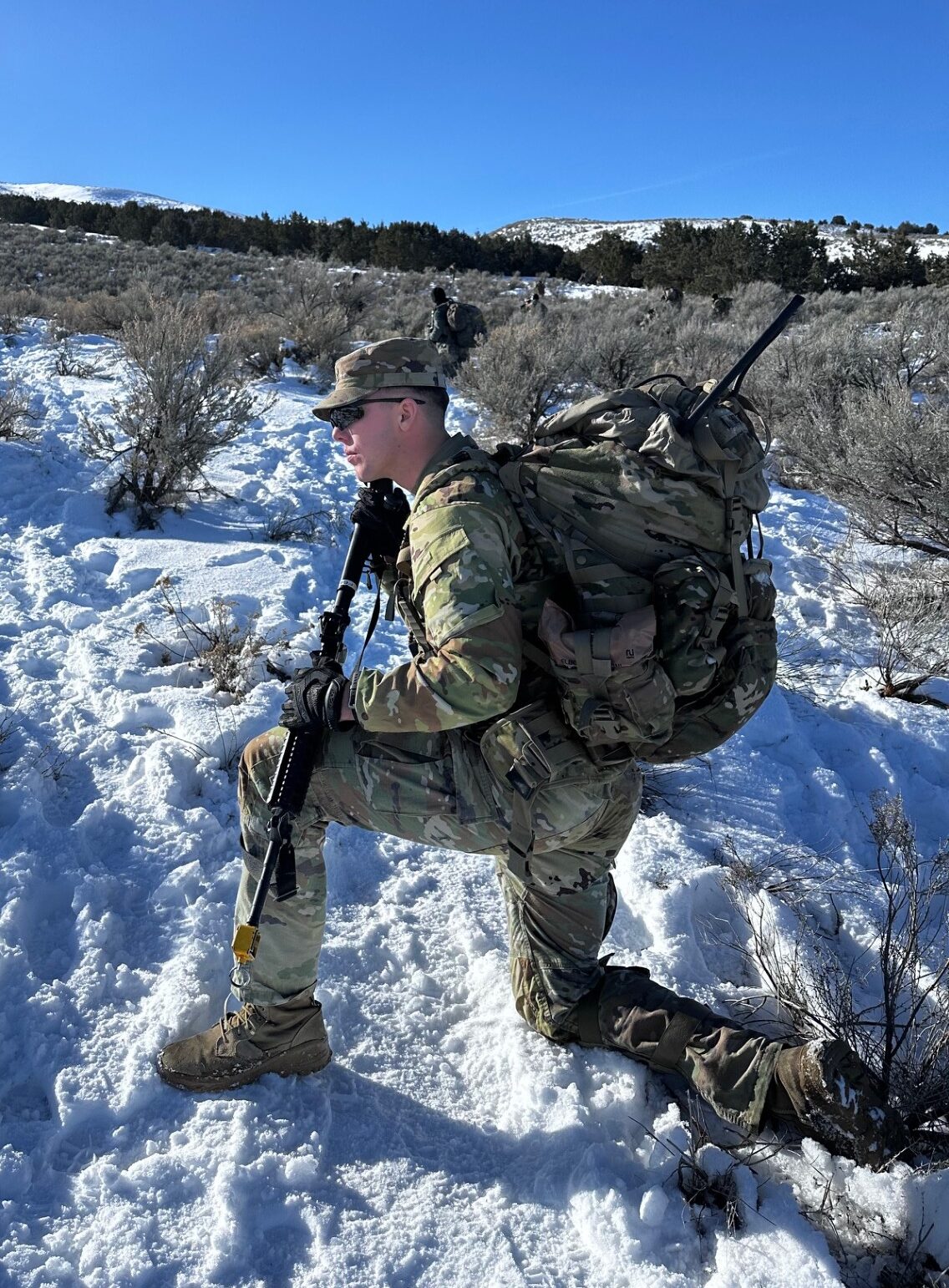 Soldier kneels ready in the snow