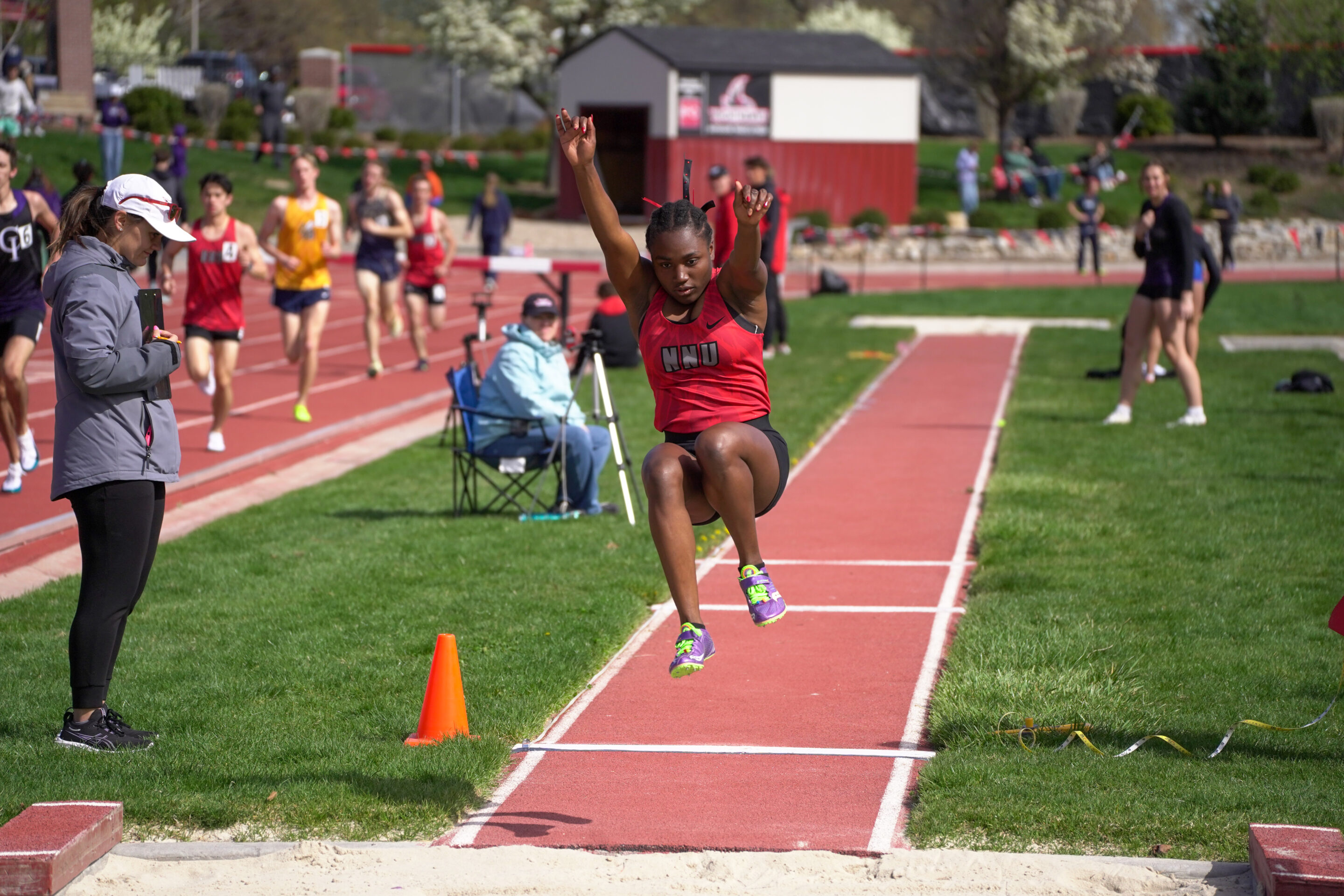 NNU04657 NNU long jumper leaps in the air before she hits the sand