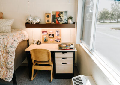 Sutherland room picture; desk with shelf and the end of a bed