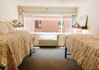 Sutherland room picture; two beds against the walls and exterior window