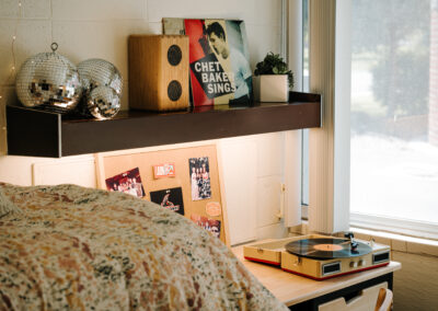 Sutherland room picture; end of bed, desk with shelf and decorations
