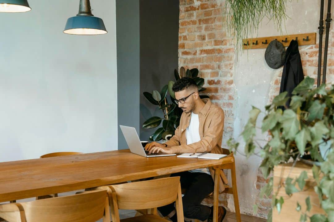 Male adult student in coffee shop on his computer
