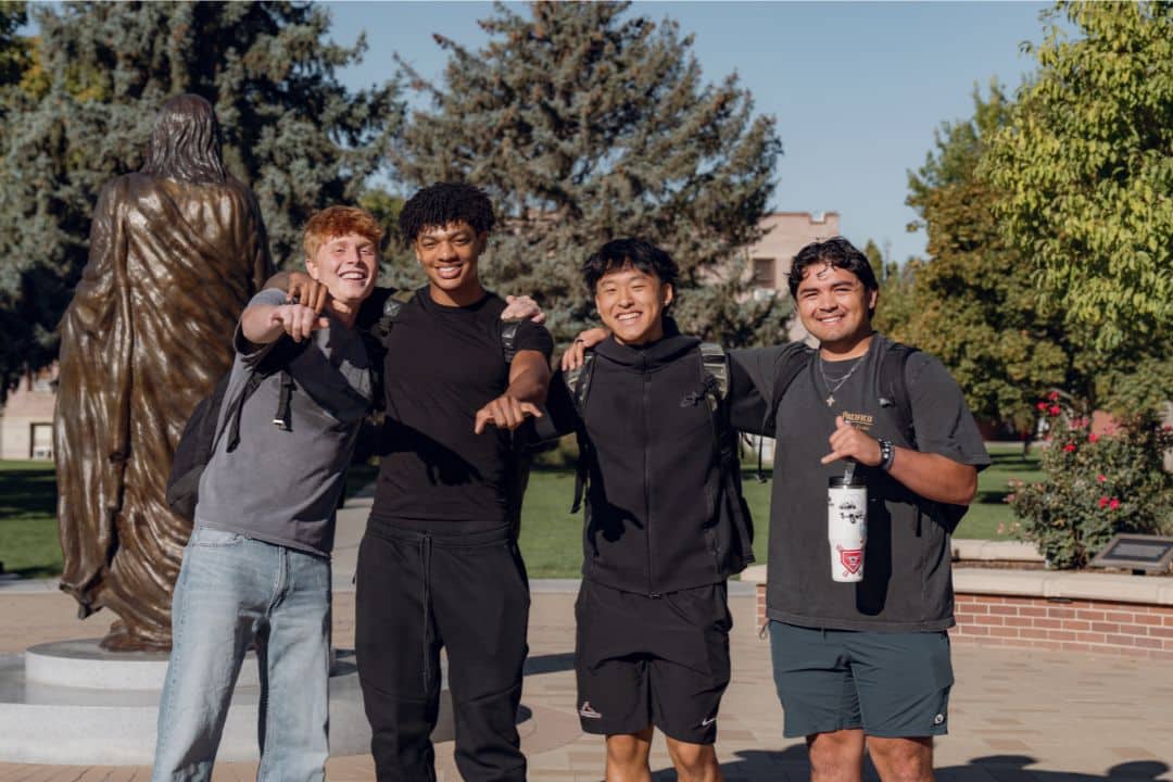 Male students on the quad near the Jesus Statue.