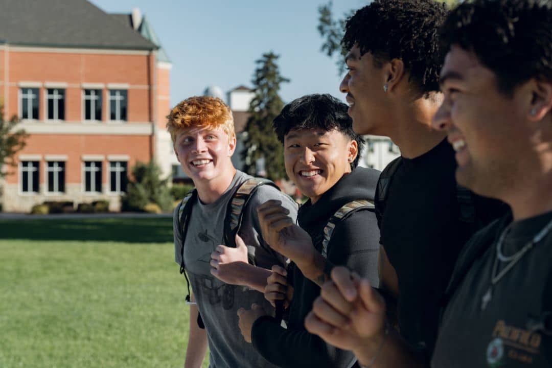 Male students walking across campus