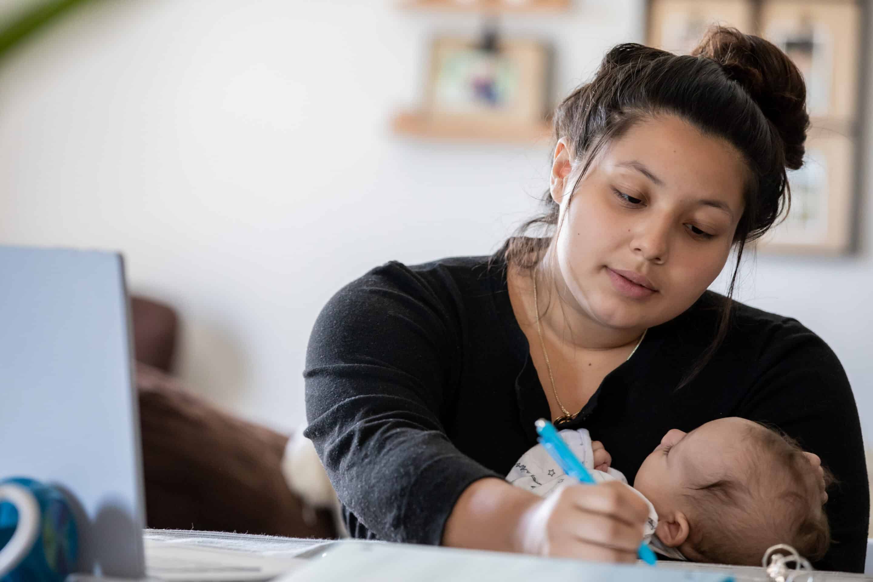 Mother with child while working on school work form home