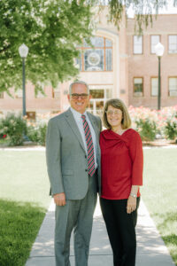 President Mark DeMichael and First Lady Kim DeMichael in front of the Emerson Building