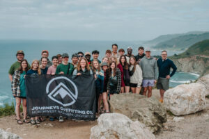 The Journeys team on a trip in california taking a picture with their flag and their leader Lance Howard