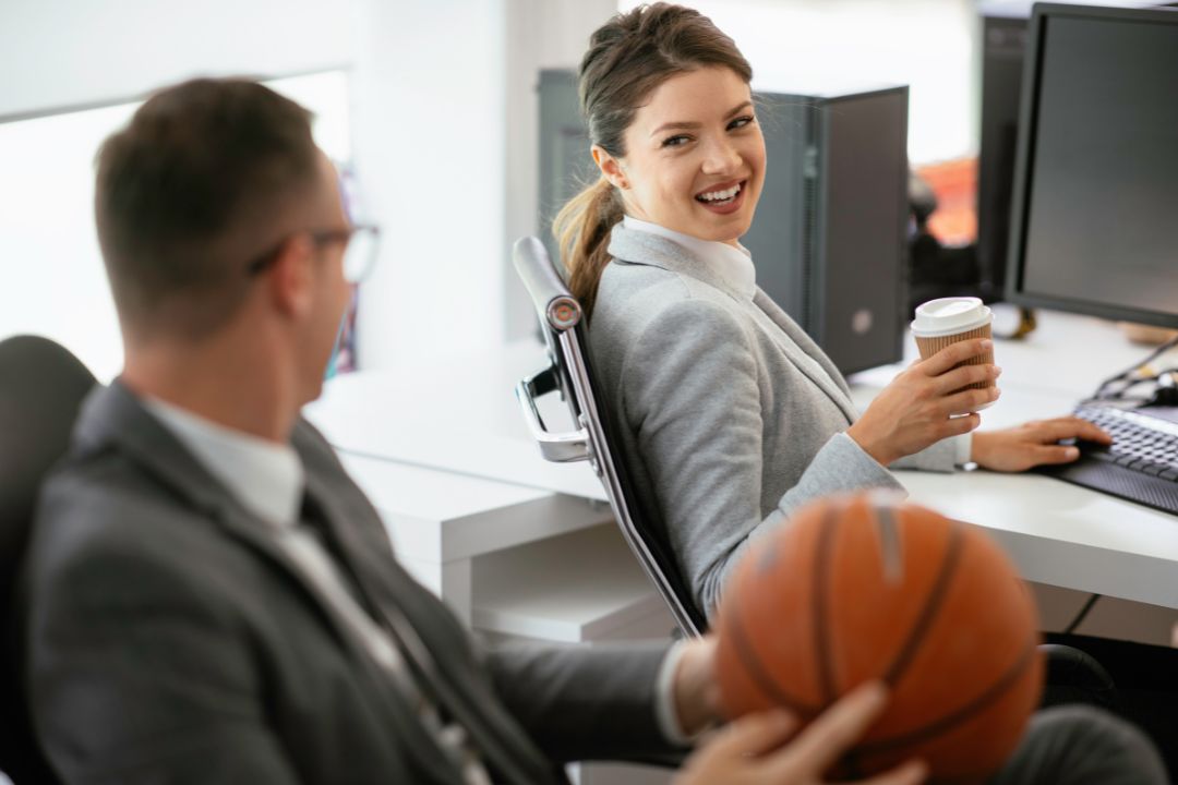Male and female in office talking about sports