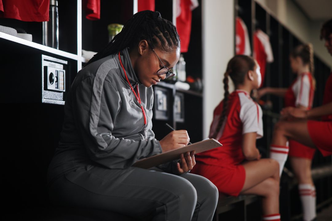 Female Coach writing on clip board