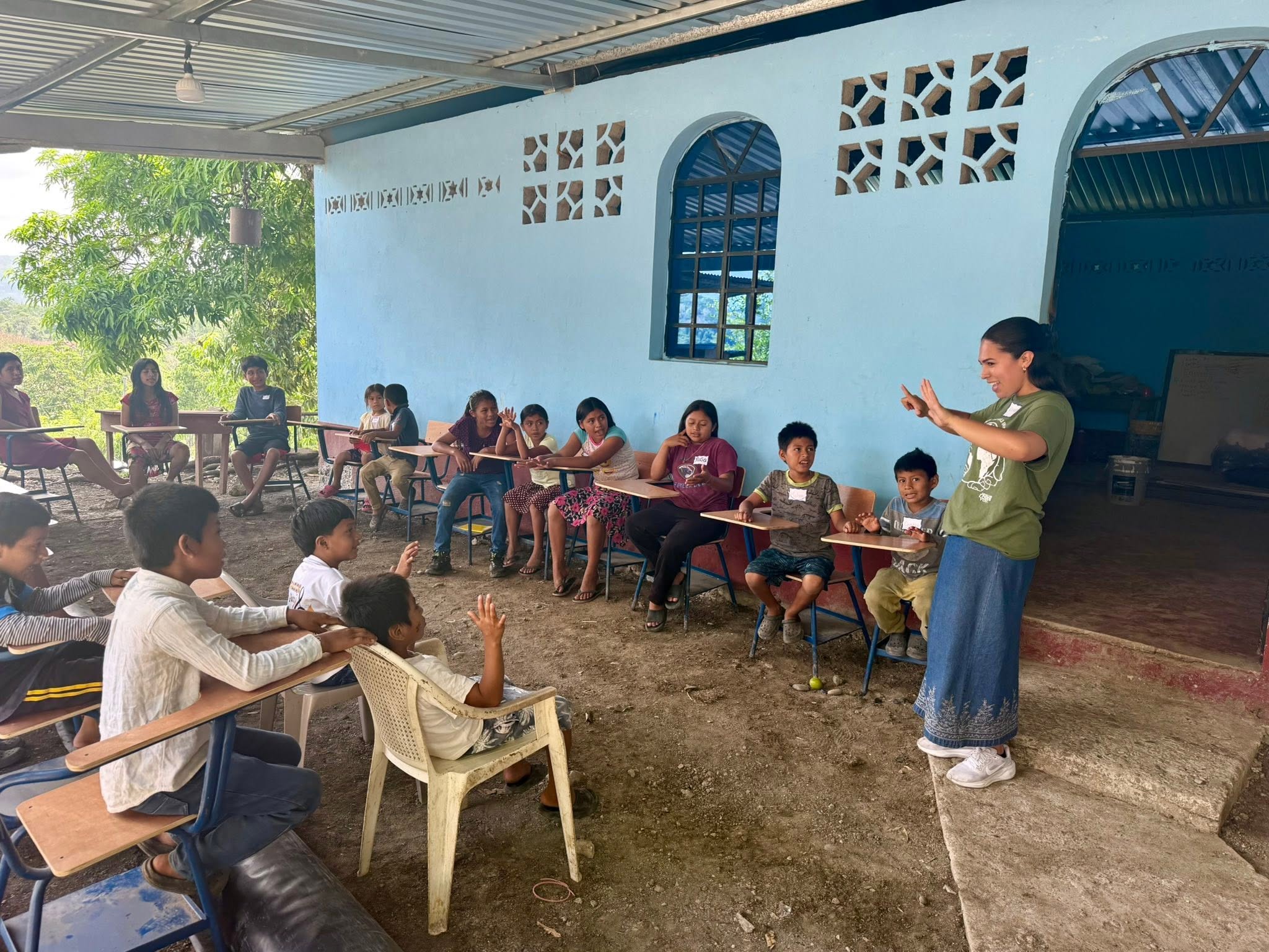 Students on a mission trip teaching young children in school 